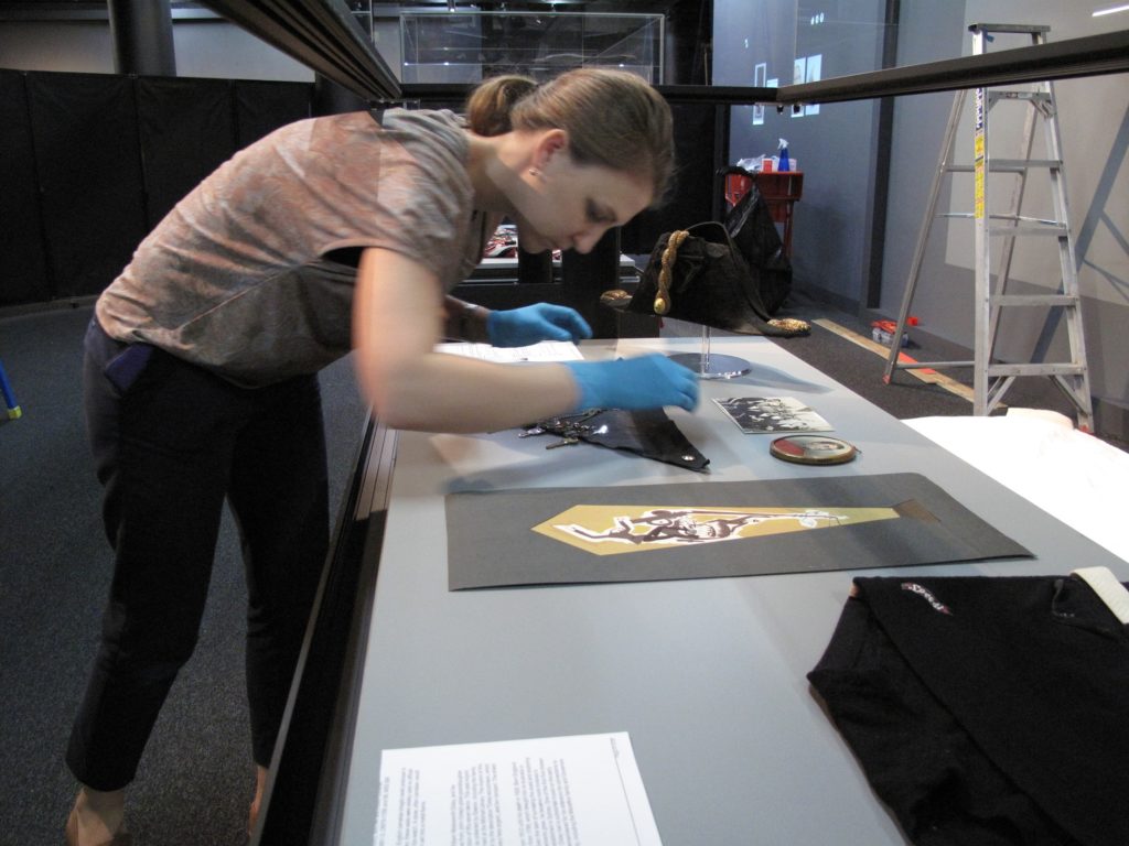Vanessa Thorne, Assistant Curator (MAAS) installing objects in Australian Men’s Style